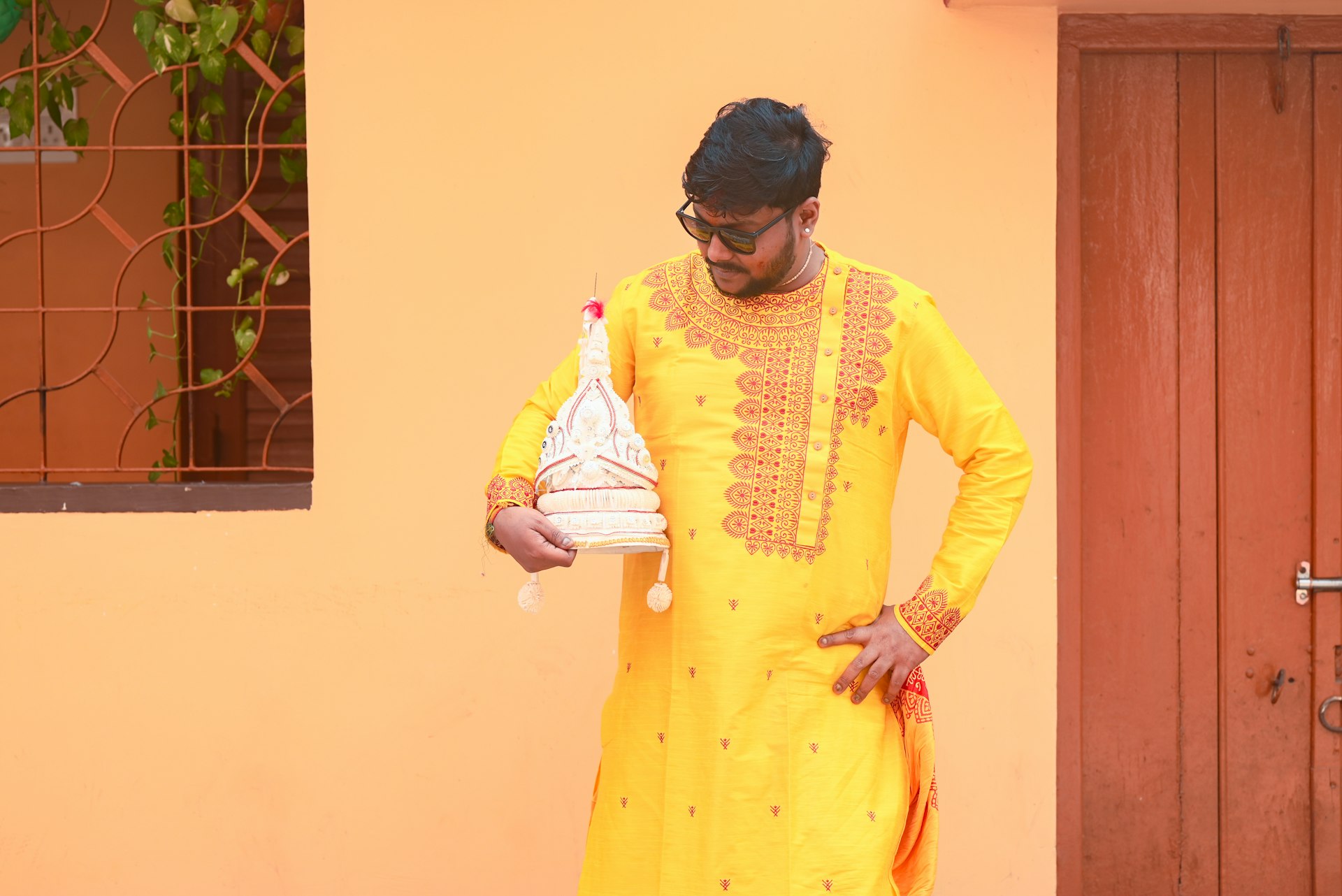 A man in a yellow outfit holding a jug
